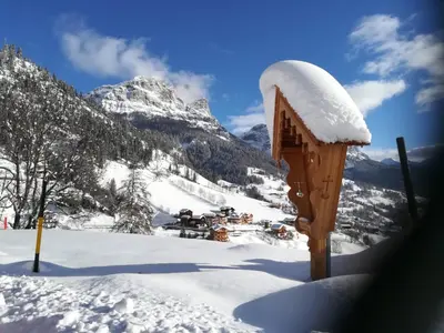 a snow covered mountain with a wooden structure in the foreground at Vista Pelmo in Colle Santa Lucia