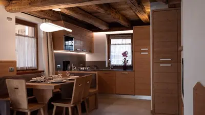 a kitchen with a wooden table and chairs and a dining room at Chalet Stella Alpina in Val di Zoldo