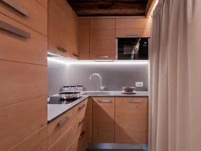a kitchen with wooden cabinets and a sink at Chalet Stella Alpina in Val di Zoldo