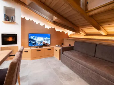 a living room with a couch and a flat screen tv at Chalet Stella Alpina in Val di Zoldo