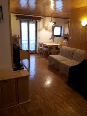a living room with a couch and a table with a tv at Nuovo Appartamento Les Corceles in San Vigilio Di Marebbe