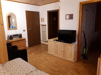a living room with a flat screen tv on a cabinet at Nuovo Appartamento Les Corceles in San Vigilio Di Marebbe