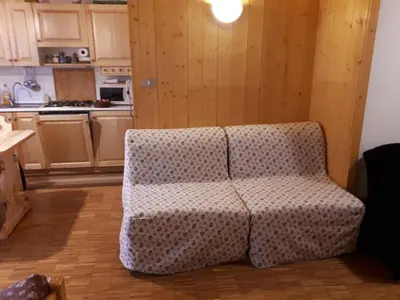 a living room with a couch in a kitchen at Nuovo Appartamento Les Corceles in San Vigilio Di Marebbe