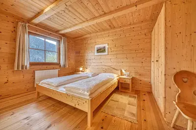 a bedroom with a bed in a wooden cabin at Zyprianhof in Nova Levante