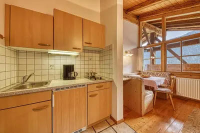 a kitchen with wooden cabinets and a sink and a window at Zyprianhof in Nova Levante