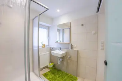 a bathroom with a sink and a shower with a mirror at Apartments Hubertus - central St Leonhard - free parking - Netflix - PasseiertalCard included - hiking and biking from doorstep in San Leonardo in Passiria