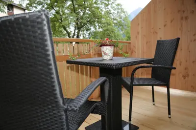 a black table and two chairs on a deck at Apartments Hubertus - central St Leonhard - free parking - Netflix - PasseiertalCard included - hiking and biking from doorstep in San Leonardo in Passiria