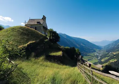 an old house sitting on top of a hill at Apartments Hubertus - central St Leonhard - free parking - Netflix - PasseiertalCard included - hiking and biking from doorstep in San Leonardo in Passiria