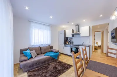 a living room with a couch and a kitchen at Apartments Hubertus - central St Leonhard - free parking - Netflix - PasseiertalCard included - hiking and biking from doorstep in San Leonardo in Passiria