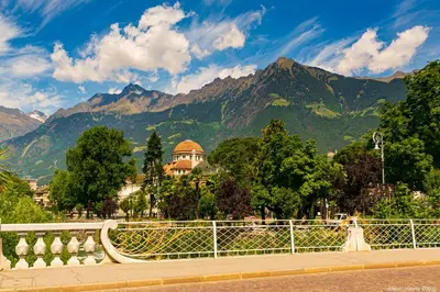 a bench on a bridge with mountains in the background at Apartment Terme in Merano