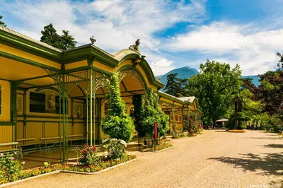 a yellow building with plants and flowers on a street at Apartment Terme in Merano