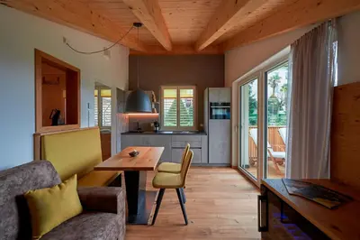 a living room with a table and a kitchen at Weingut Windegg in Caldaro