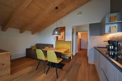 a kitchen and living room with a table and chairs at Weingut Windegg in Caldaro