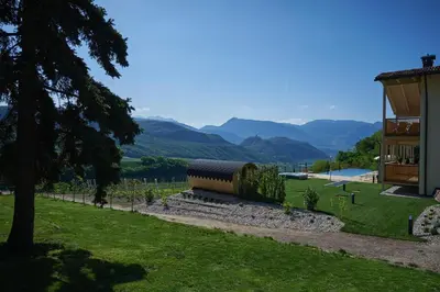 a train sitting in a field next to a building at Weingut Windegg in Caldaro