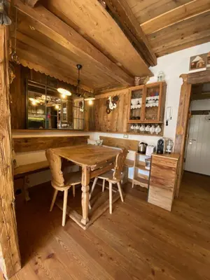 a kitchen with a wooden table and chairs at Calore di una Casa di Montagna in Campitello di Fassa