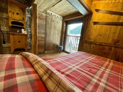a bedroom with a bed in a wooden cabin at Calore di una Casa di Montagna in Campitello di Fassa