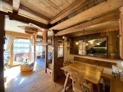 a wooden room with a table and a bed at Calore di una Casa di Montagna in Campitello di Fassa
