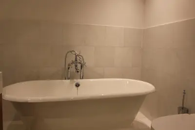 a white bath tub in a bathroom with a toilet at Augustiner in Meran in Merano