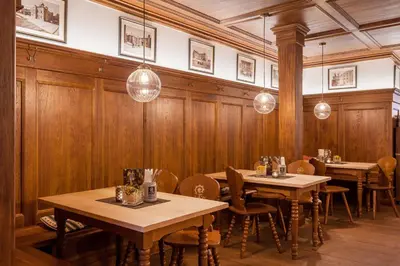 a restaurant with wooden walls and tables and lights at Augustiner in Meran in Merano