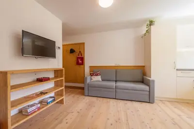 a living room with a couch and a flat screen tv at Chalet Martin in Valdaora