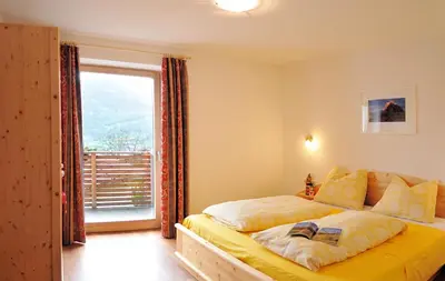 a bedroom with a bed and a large window at Appartements Schusterbauer in Naz-Sciaves