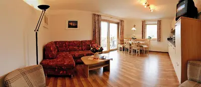 a living room with a red couch and a table at Appartements Schusterbauer in Naz-Sciaves