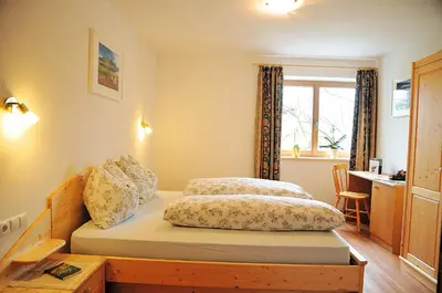 a bedroom with two beds and a desk and a window at Appartements Schusterbauer in Naz-Sciaves