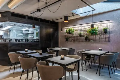 a restaurant with tables and chairs in a room at Stay COOPER l Cooper apartments in Bolzano