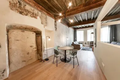 a room with a table and chairs and a living room at Stay COOPER l Cooper apartments in Bolzano