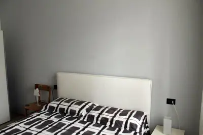 a bed with a black and white blanket on it at Plose Apartment in Bressanone