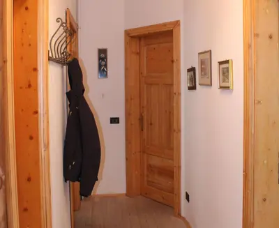 a hallway with a door and a coat hanging on a wall at Plose Apartment in Bressanone