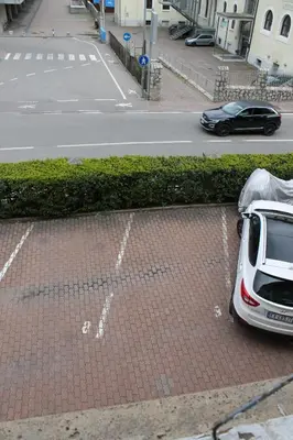 a white car parked next to a parking lot at Plose Apartment in Bressanone