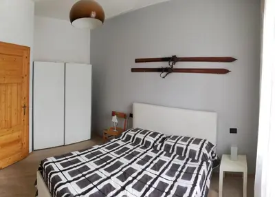 a bedroom with a bed with a black and white comforter at Plose Apartment in Bressanone