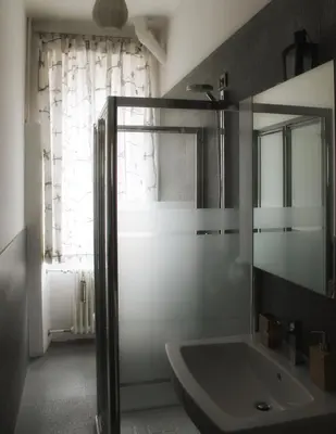 a bathroom with a glass shower and a sink at Plose Apartment in Bressanone
