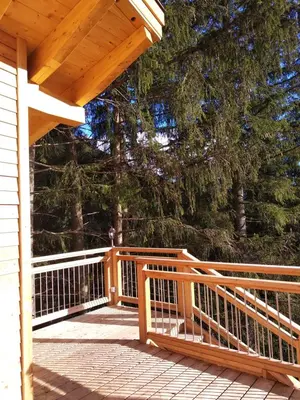 a wooden porch with a wooden railing on a house at Eco-Green Fiores Agriturismo in Vigo di Fassa
