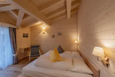 a bedroom with a bed in a wooden room at Eco-Green Fiores Agriturismo in Vigo di Fassa