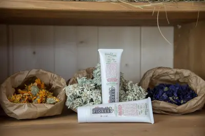 a shelf with a bottle of toothpaste and two bags of dried flowers at Eco-Green Fiores Agriturismo in Vigo di Fassa