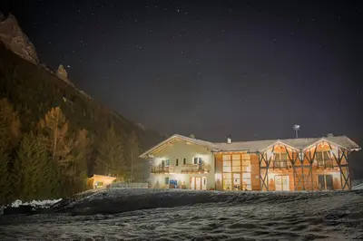 a large house at night with the lights on at Eco-Green Fiores Agriturismo in Vigo di Fassa