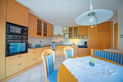 a kitchen with a table with a blue table cloth on it at Chalet Prinoth in Selva di Val Gardena