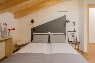 a bedroom with a large bed and a wooden ceiling at Orizzonti d'Anaunia in Tassullo