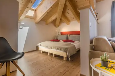a bedroom with a bed in a room with wooden ceilings at Orizzonti d'Anaunia in Tassullo