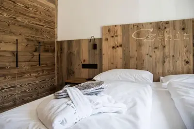 a bedroom with white towels on a bed at Chalet Zenit in Selva di Val Gardena