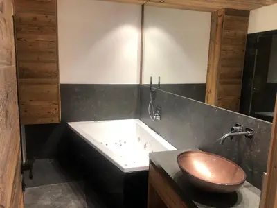 a bathroom with a wooden toilet and a tub at Chalet Zenit in Selva di Val Gardena