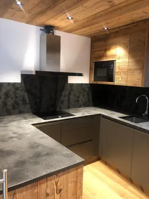a kitchen with gray counter tops and wooden ceilings at Chalet Zenit in Selva di Val Gardena