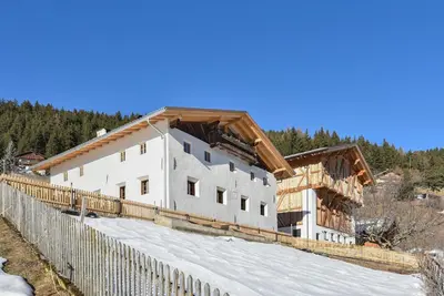 a building with a wooden roof on top of a fence at ban Hofa in Bressanone