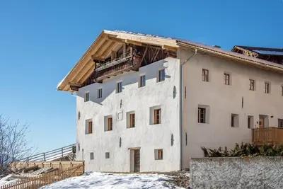 a large white building with snow on the ground at ban Hofa in Bressanone