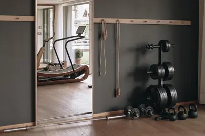 a gym with a mirror and exercise equipment at Villa Arnica, a Member of Design Hotels in Lana