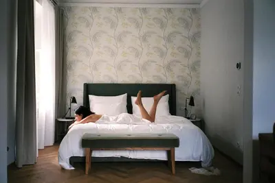 a woman laying on a bed with her feet up at Villa Arnica, a Member of Design Hotels in Lana