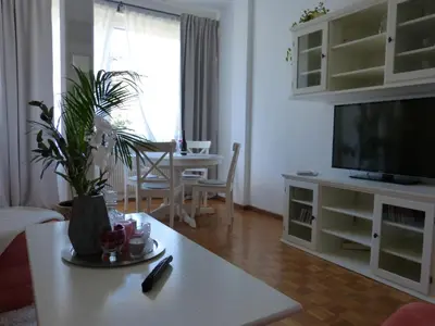 a living room with a table and a tv at Appartamento centro terme merano in Merano
