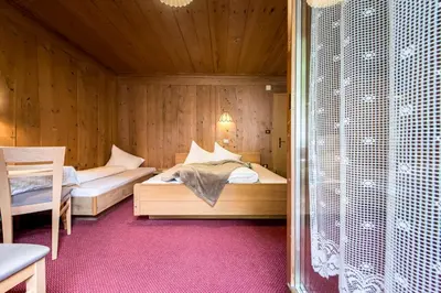 a bedroom with two beds in a wooden room at Oberwirt in Selva dei Molini